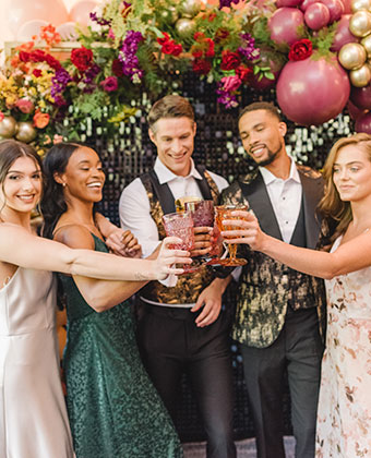 A group of young people cheersing their glasses at an event